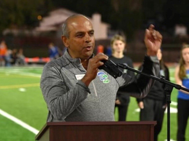 Parth speaking on a football field.